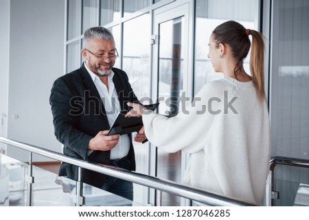 Employee is going to take the documents from the businessman in classic wear.