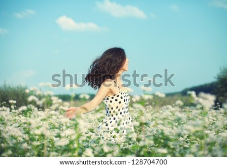 Young happy girl walking on the buckwheat field Royalty-Free Stock Photo #128704700