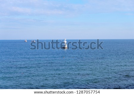 Fishing boat and lighthouse in the gulf with blue sky and sea background, Chonburi, Thailand.