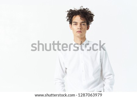 pretty business man in a white shirt with curly hair on a light background