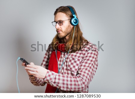 handsome man in headphones with a telephone, with long hair, isolated closeup