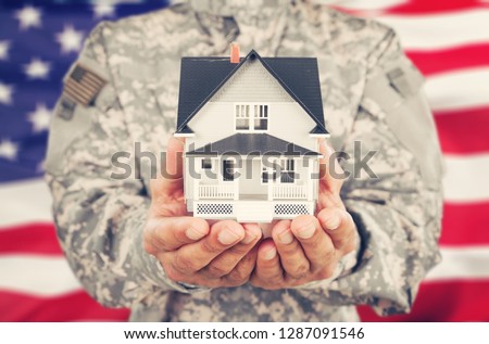 Soldier Holding a Model of House