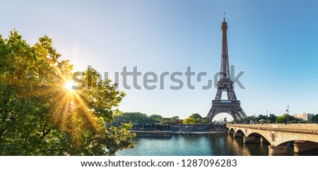 small paris street with view on the famous paris eiffel tower on a sunny day with some sunshine Royalty-Free Stock Photo #1287096283