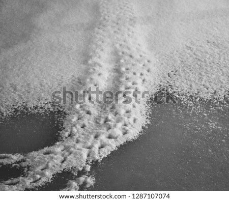 Frozen water covered with snow with traces of tread. Background picture