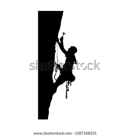 silhouette of a climber hammering a hook on a rock