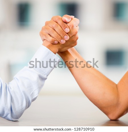 Business people arm wrestling at the office