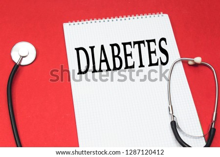 disease diabetes concept handwriting on white notebook and stethoscope on red background