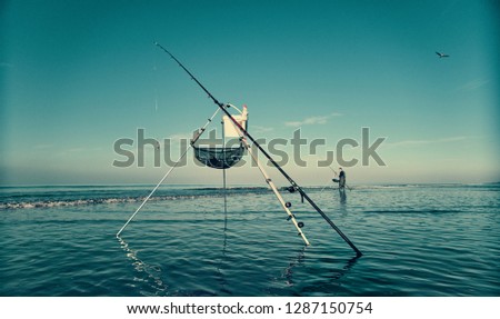 A beautiful cinematic scene of a fisherman fishing off the beach with a line and pole , with a dark blue aqua sky. Photography film colour grade. 