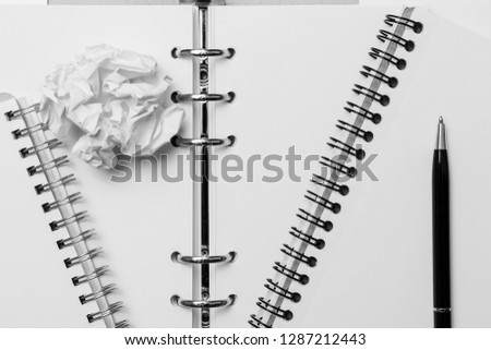 Notebook, pen and  crumpled sheet of paper. Business and learning concept. Black and white photography