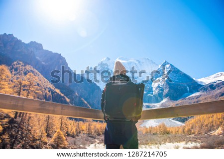 A man success  hiking in snow peak mountain at autumn, People traveling concept