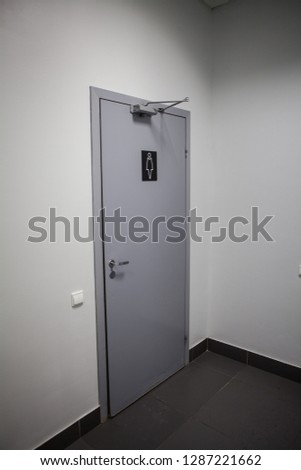 The door to the ladies ' room in a public building.