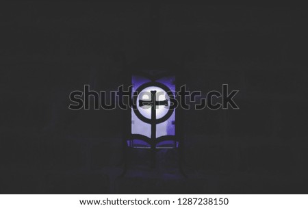 abstract cross religion sign blue light lantern illumination in darkness and shadows of underground cave