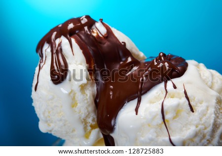ice cream in with chocolate sauce. closeup .on blue background.