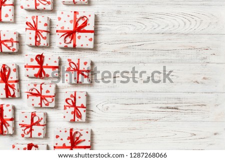 top view of various gift boxes. wrapped valentine or other holiday handmade present in paper with red ribbon and heart. Present box, decoration of gift on wooden table.