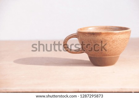 Cup of coffee on art wooden table with sunlight and shadow no more coffee