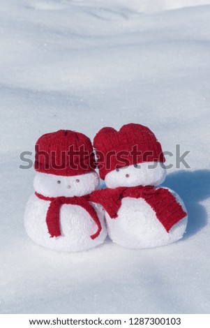 Two lovely snowmen toys on the white snow, holiday celebration concept