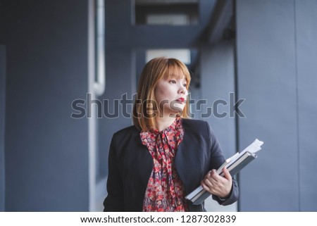 A business woman is walking to her office building. This portrait photo can be used in such concepts as financial, investor, communication, stock trader, happy, teacher and so on.