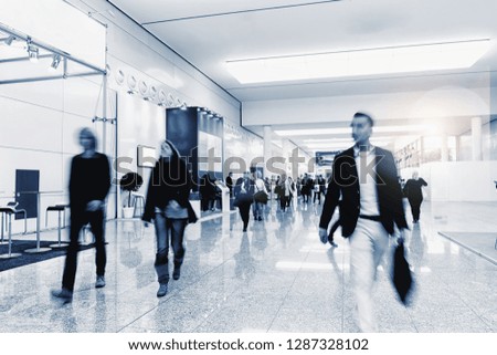 Crowd of anonymous people walking on a trade show