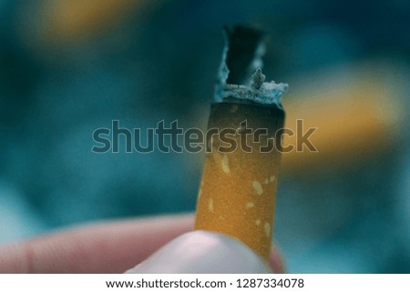 Macro photo of the cigarette butts background. Royalty high-quality stock closeup photo image of dirty cigarettes butt. A lot of burnt cigarette butts with some ash with copy space for text design