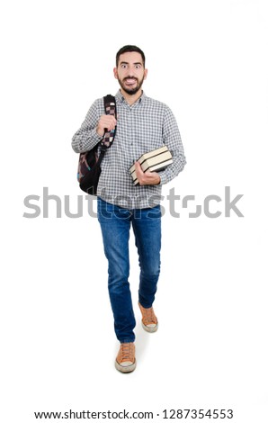 Full length picture of a young excited male student walking towards the camera with a smile on his face. Isolated on white background 