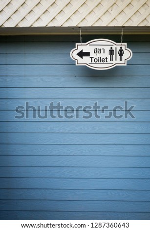 Vintage toilet sign on the blue wooden wall with restroom in Thai word
