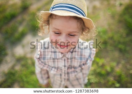Cute baby girl in a straw hat portrait outdoor in summer day. Shooting from above