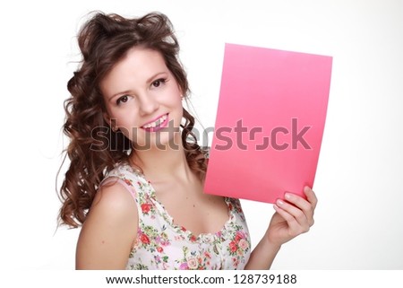 Young smiling woman wearing clothes with floral ornament and showing pink blank card