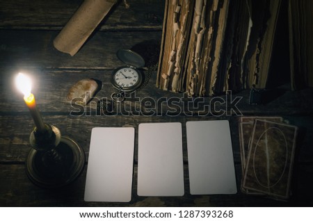 Tarot cards with copy space mockup on fortune teller table in the lights of burning candle background. Futune reading concept. Divination.