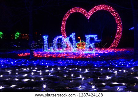 The inscription love and the shape of the heart of the LEDs, which were installed in a city park in Europe, shot at night on the big screen