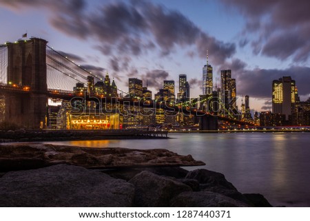 View of the Brooklyn Bridge and Manhattan from the riverside of the East River at sunset 