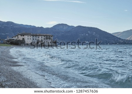 Crashing waves and colored buildings in Lake Como in Italy on a winter day