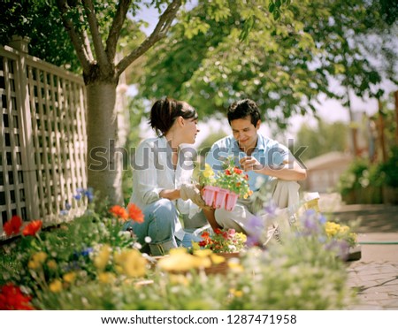 Young couple happily tending to their garden.