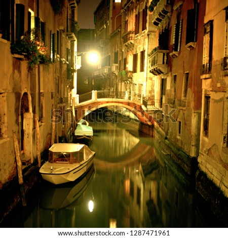 A quaint old bridge over a canal at night, Venice, Italy.