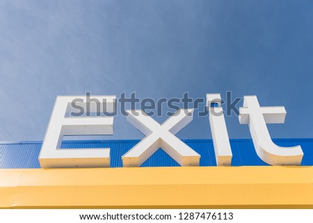 Lookup view to Exit sign again cloud blue sky