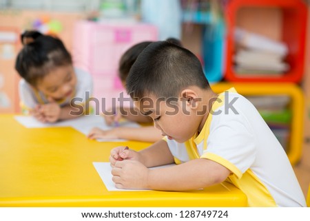Closeup of an asian boy drawing something