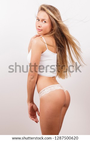 Beautiful blond girl posing for photo at home studio on the white wall