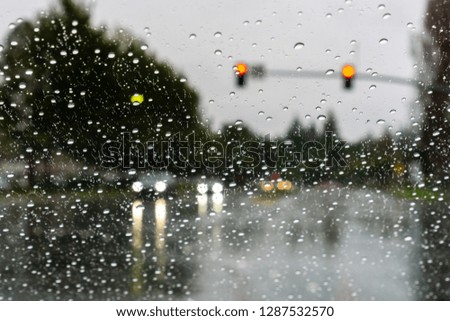 Cars driving through rain; raindrops on the windshield