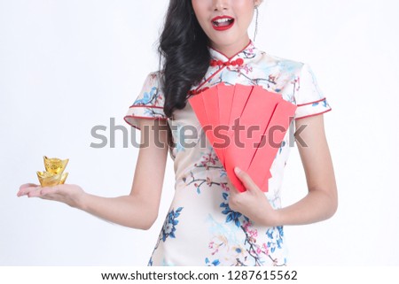 Crop image of Beautiful smiling Chinese woman is holding gold and red packet of Ang Pao present of Chinese New Year. given during holidays or special occasions.