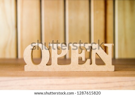 Wooden open signage on the shelf for welcome