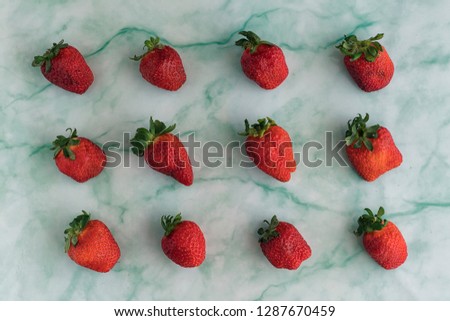 Patterned isolated strawberries overview in a blue marble background
