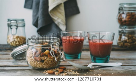 Breakfast with granola and strawberry banana smoothie. Rustic wooden table, white background, toned photo. HD size