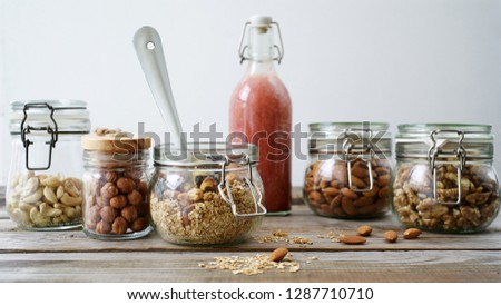 Breakfast with granola, strawberry banana smoothie and nuts. Rustic wooden table, white background. HD size