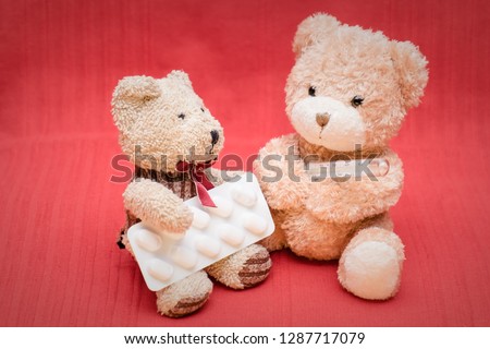 decorations two toy bears on the red carpet measures temperature with a mercury thermometer and pills