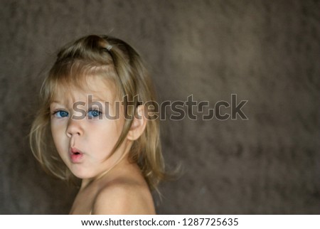 surprised little girl looking at camera with astonishment