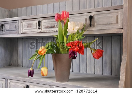 Tulips on an old fashioned bookshelf in shabby chic, Royalty-Free Stock Photo #128772614