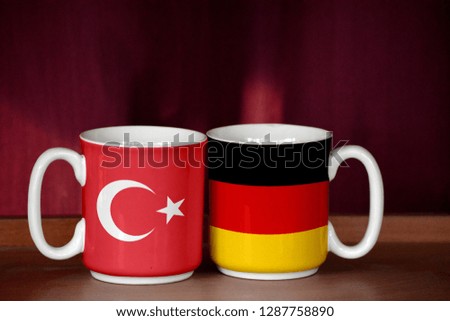 Germany and Turkey flag on two cups with blurry background