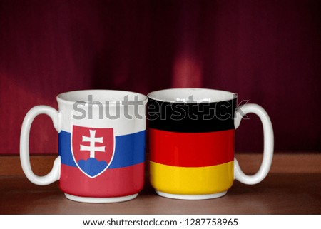 Germany and Slovakia flag on two cups with blurry background