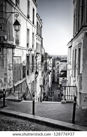 From the top of a typical staircase in Montmartre Hill, we see Paris skyline in the background. Black and white.