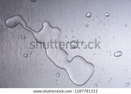 Brushed metal surface with water drops       