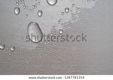 Brushed metal surface with water drops       